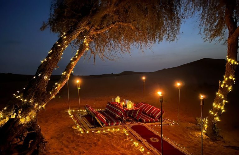 Private camp setup in desert during evening with light